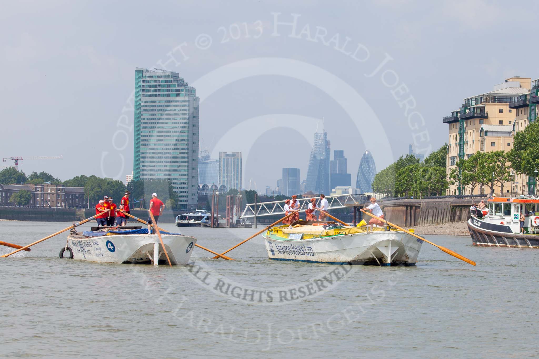 TOW River Thames Barge Driving Race 2013: Barge "Hoppy", by GPS Fabrication, approaching Masthouse Terrace Pier. On the left barge "Spirit of Mountabatten", by Mechanical Movements and Enabling Services Ltd. In the background the skyscrapers of the City of London. On the very left an oar of barge "Darren Lacey"..
River Thames between Greenwich and Westminster,
London,

United Kingdom,
on 13 July 2013 at 12:41, image #168