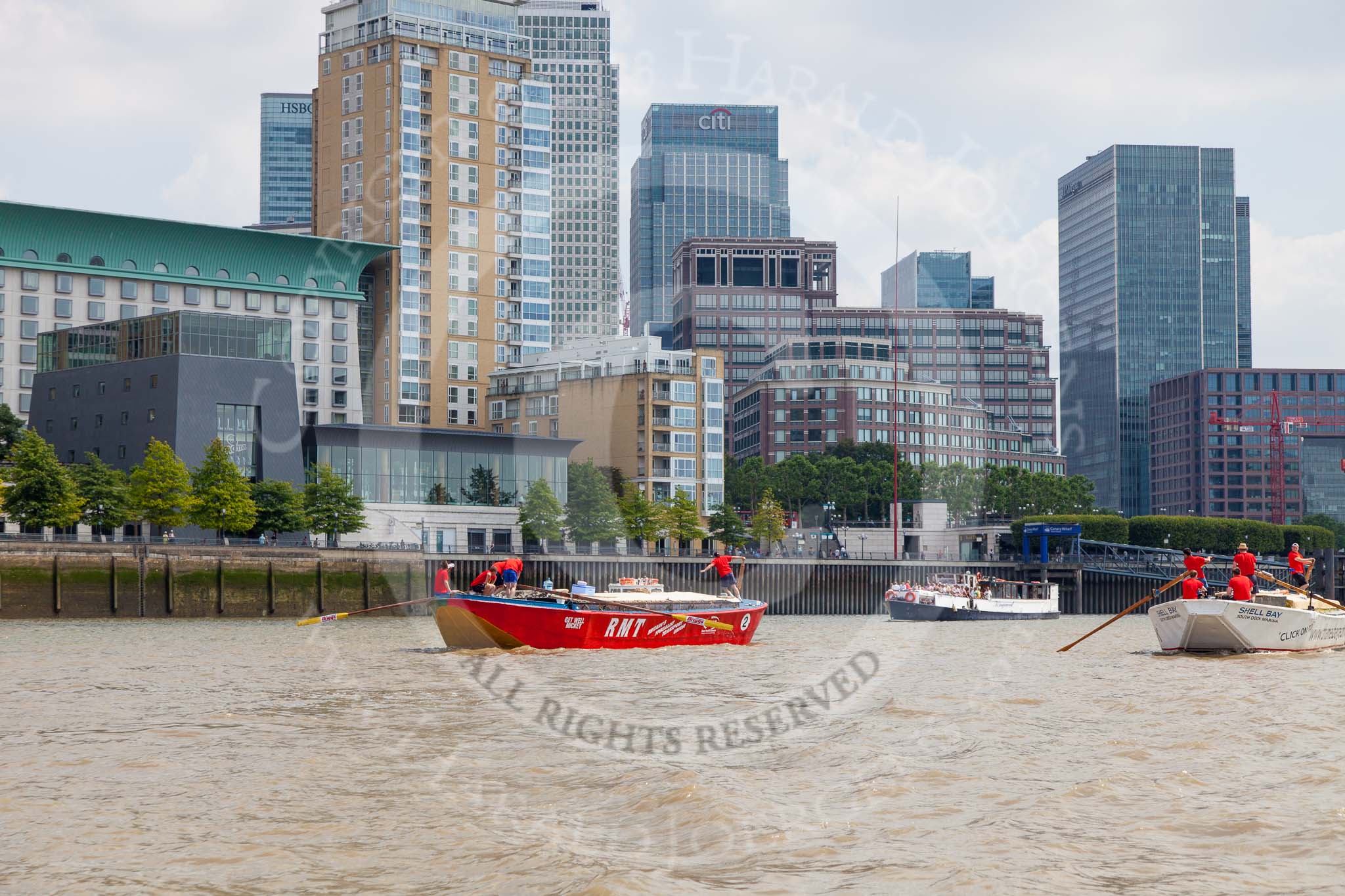 TOW River Thames Barge Driving Race 2013: Barge "Jane", by the RMT Union, followed by barge"Shell Bay" by South Dock Marina,  in front of the skyscrapers at Canary Wharf..
River Thames between Greenwich and Westminster,
London,

United Kingdom,
on 13 July 2013 at 13:16, image #304