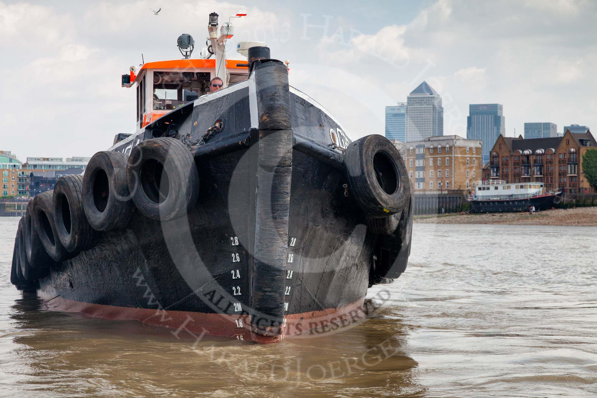 TOW River Thames Barge Driving Race 2013: The bow of GPS Marine tug "GPS Vincia" at close distance. In the background the skyscrapers of Canary Wharf..
River Thames between Greenwich and Westminster,
London,

United Kingdom,
on 13 July 2013 at 13:30, image #351