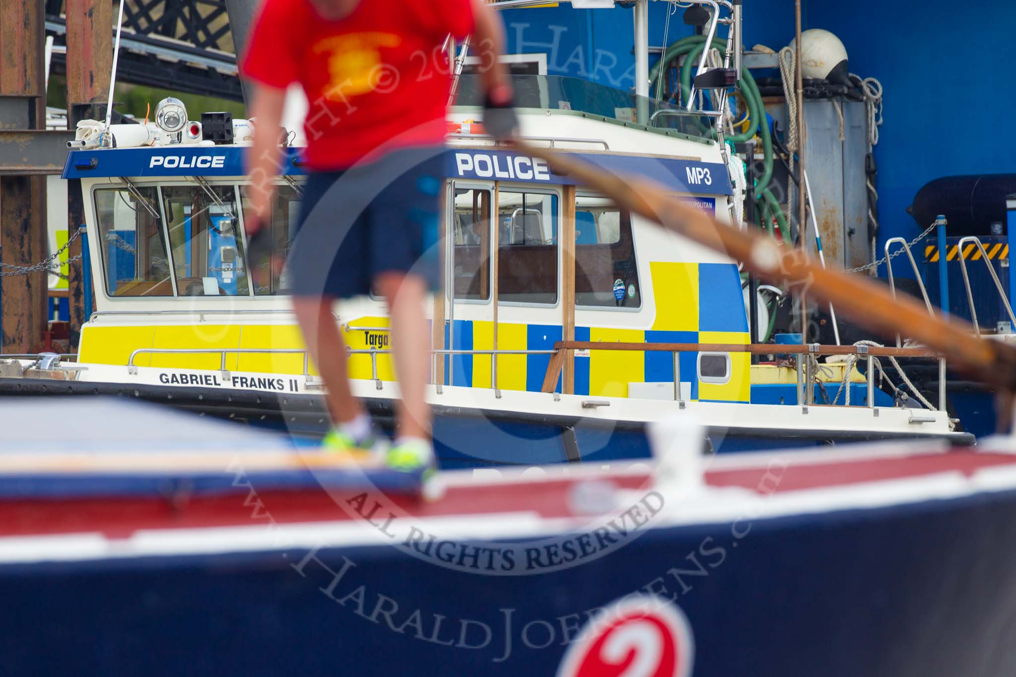 TOW River Thames Barge Driving Race 2013: The steerer on board of barge "Blackwall", by the Port of London Authority, out of focus as the barge passes Metropolitan Police boats..
River Thames between Greenwich and Westminster,
London,

United Kingdom,
on 13 July 2013 at 13:32, image #356