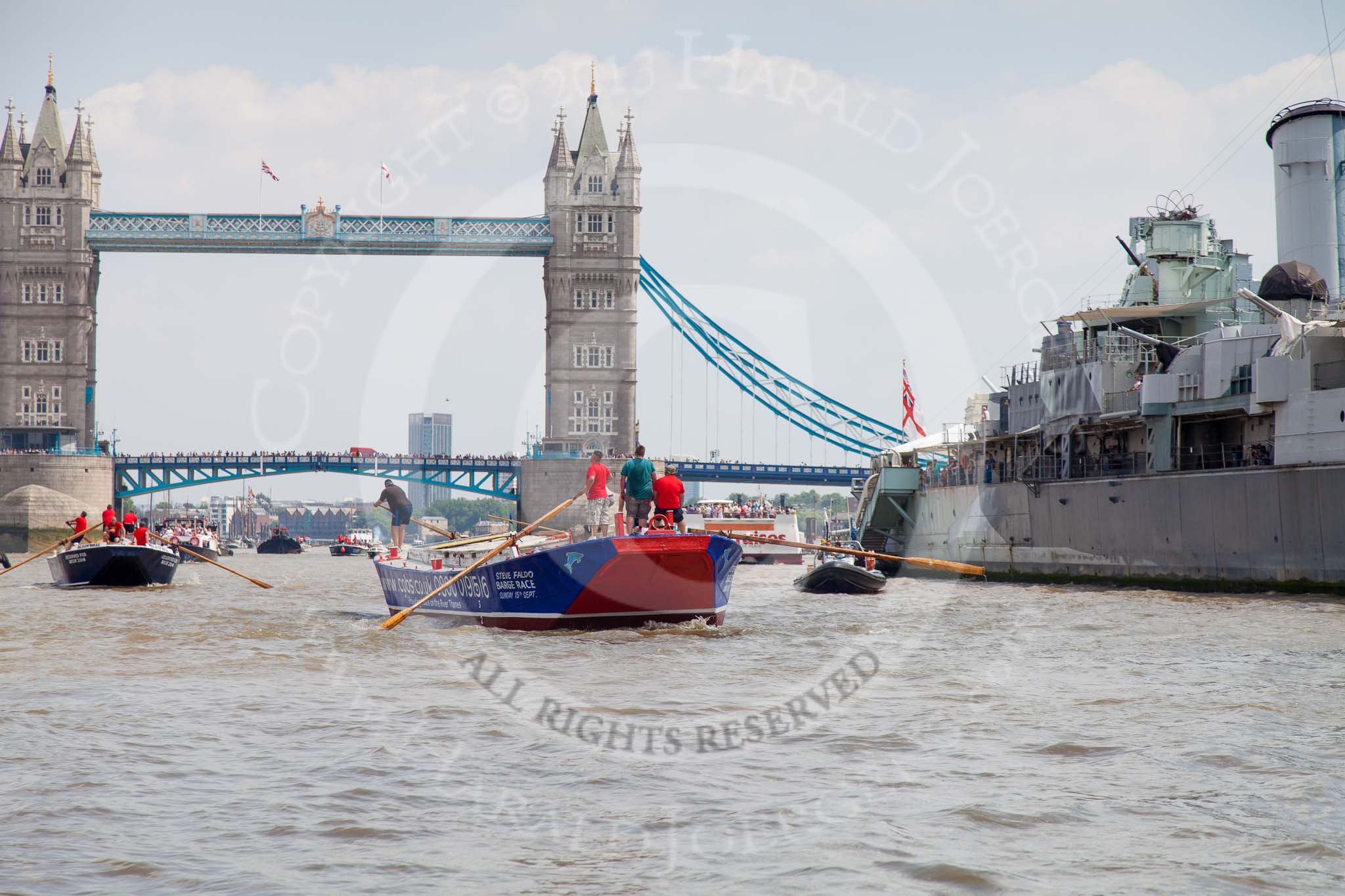 TOW River Thames Barge Driving Race 2013: Barge "Steve Faldo" by Capital Pleasure Boats, followed by barge "Blackwall", by the Port of London Authority, passing HMS Belfast, with Tower Bridge in the background..
River Thames between Greenwich and Westminster,
London,

United Kingdom,
on 13 July 2013 at 13:48, image #398