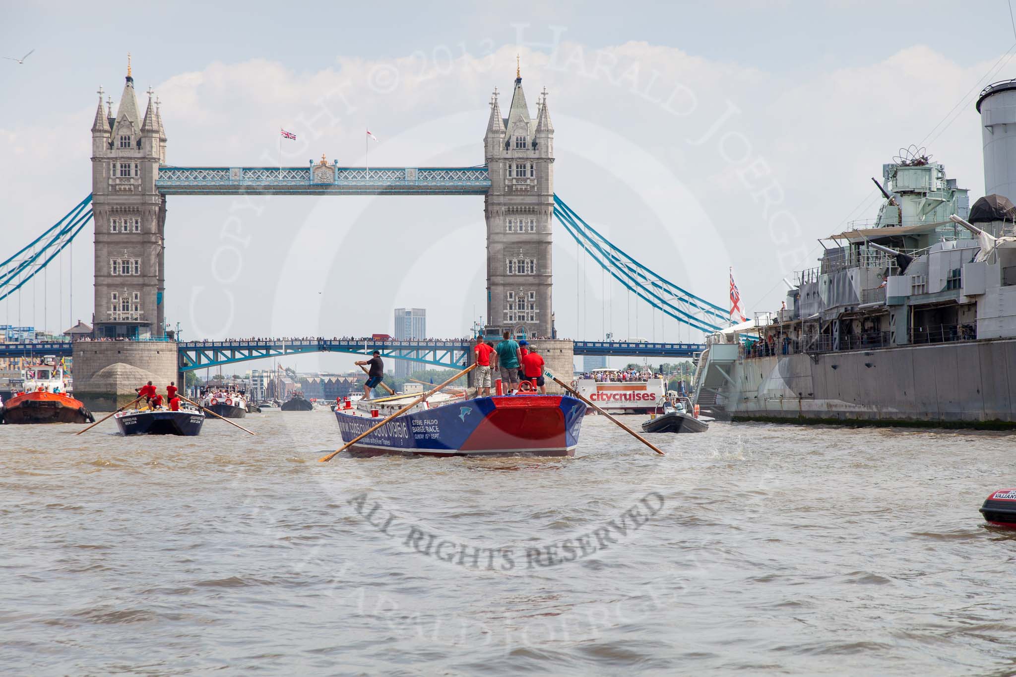 TOW River Thames Barge Driving Race 2013: Barge "Steve Faldo" by Capital Pleasure Boats, followed by barge "Blackwall", by the Port of London Authority, passing HMS Belfast, with Tower Bridge in the background..
River Thames between Greenwich and Westminster,
London,

United Kingdom,
on 13 July 2013 at 13:48, image #399