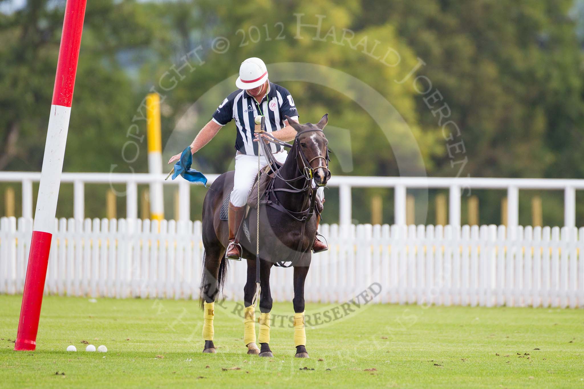 DBPC Polo in the Park 2012: The umpire and club polo manager Ian 'Ginger' Hunt, dropping a goal flags at one goal in preparation for the first match..
Dallas Burston Polo Club,
Stoneythorpe Estate,
Southam,
Warwickshire,
United Kingdom,
on 16 September 2012 at 10:02, image #24