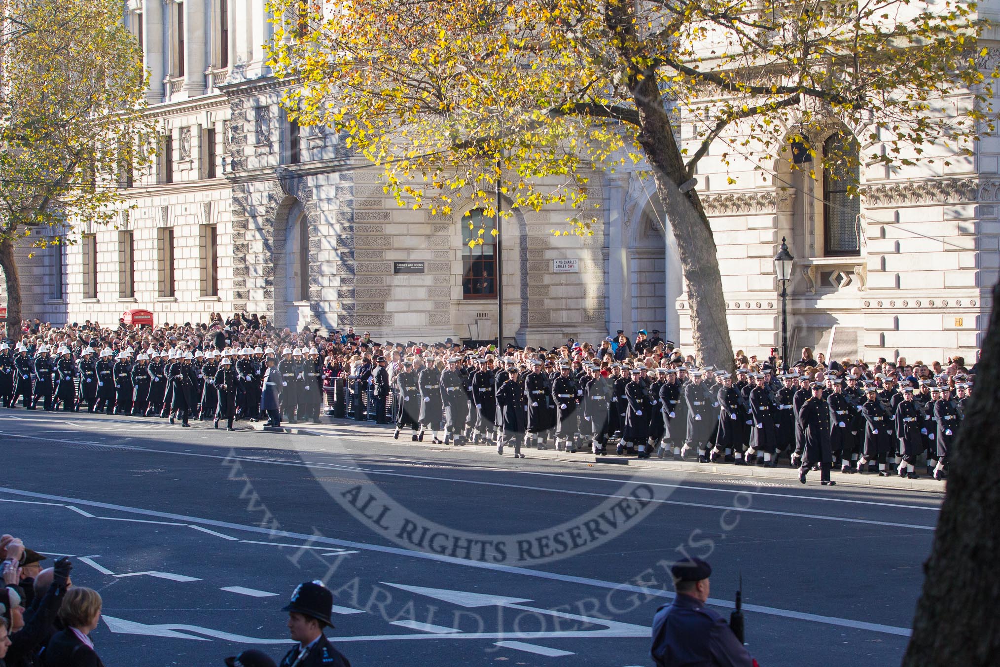 A detachment from from the Royal Navy, followed by the Royal Marines, marching along the northern side of Whitehall towards the Cenotaph.