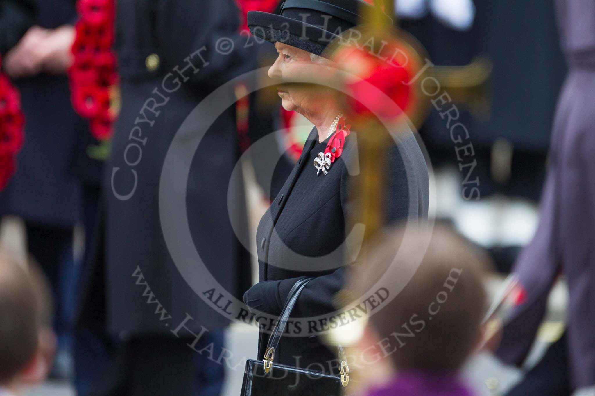 Remembrance Sunday at the Cenotaph 2015: HM The Queem at the Cenotaph, her face partially covered by the cross. Image #138, 08 November 2015 10:59 Whitehall, London, UK