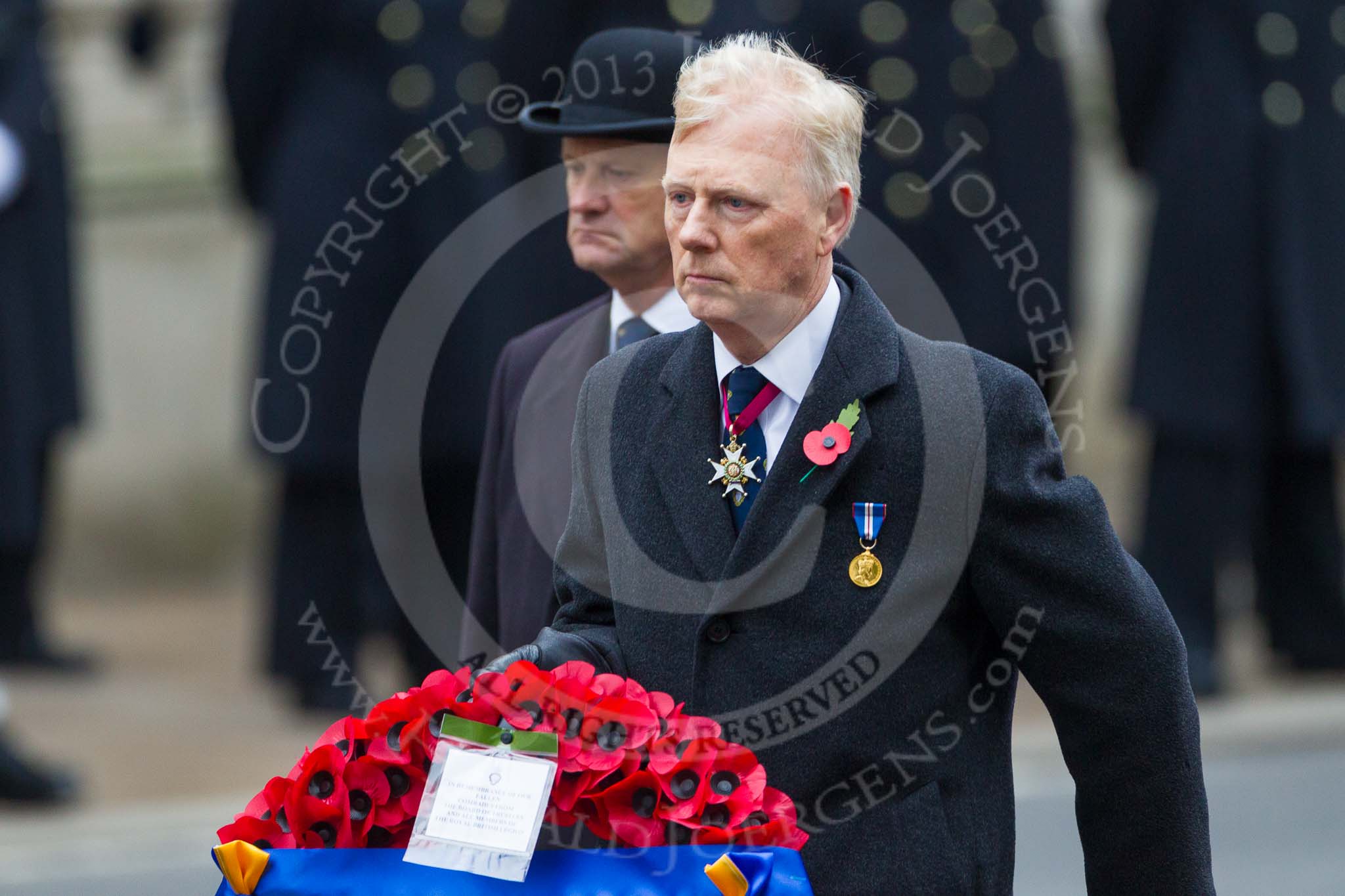 Remembrance Sunday at the Cenotaph 2015: Vice  Admiral  Peter  Wilkinson, President of the Royal British Legion, approaches the Cenotaph with his wreath. "In Remembrance of our fallen comrades from the board of trustees and all members of the Royal British Legion". Image #330, 08 November 2015 11:24 Whitehall, London, UK