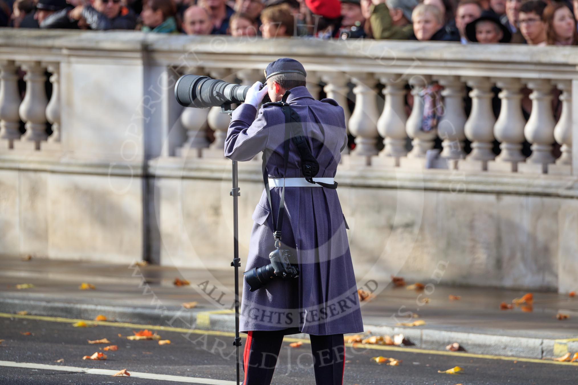 An army photographer shooting the service detachments arriving on Whitehall before the Remembrance Sunday Cenotaph Ceremony 2018 at Horse Guards Parade, Westminster, London, 11 November 2018, 10:23.