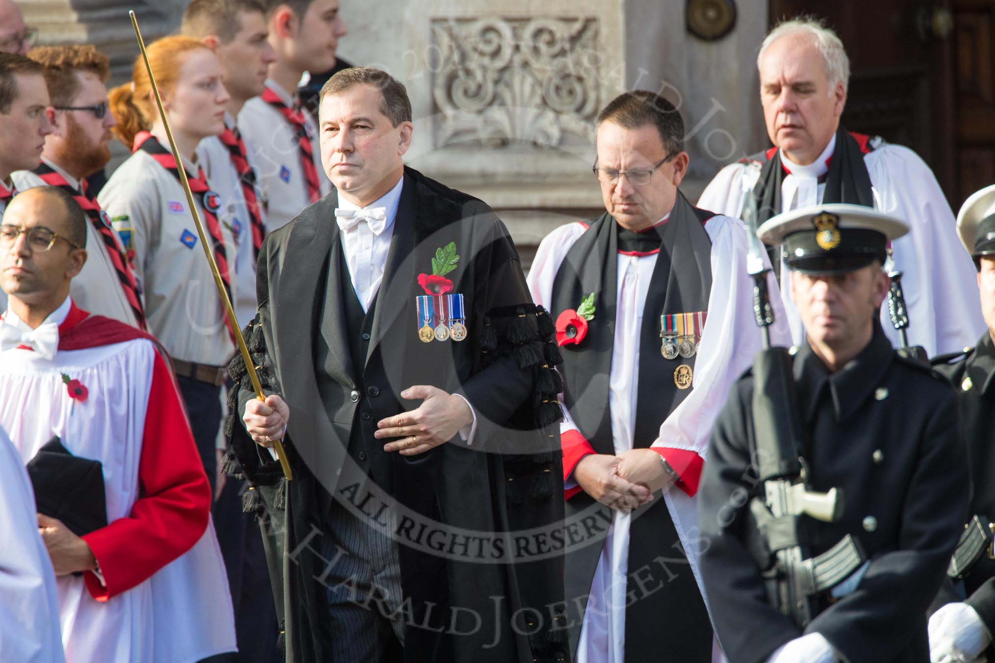 The Bishop’s Procession leaving the Foreign and Commonwealth Office, here the Director of Music, Joseph McHardy, the Serjeant of the Vestry, Mr Jonathan Simpsonm and the Forces Chaplain, the Venerable John Ellis QHC RAF, Chaplain­in­Chief to the RAF during the Remembrance Sunday Cenotaph Ceremony 2018 at Horse Guards Parade, Westminster, London, 11 November 2018, 10:53.