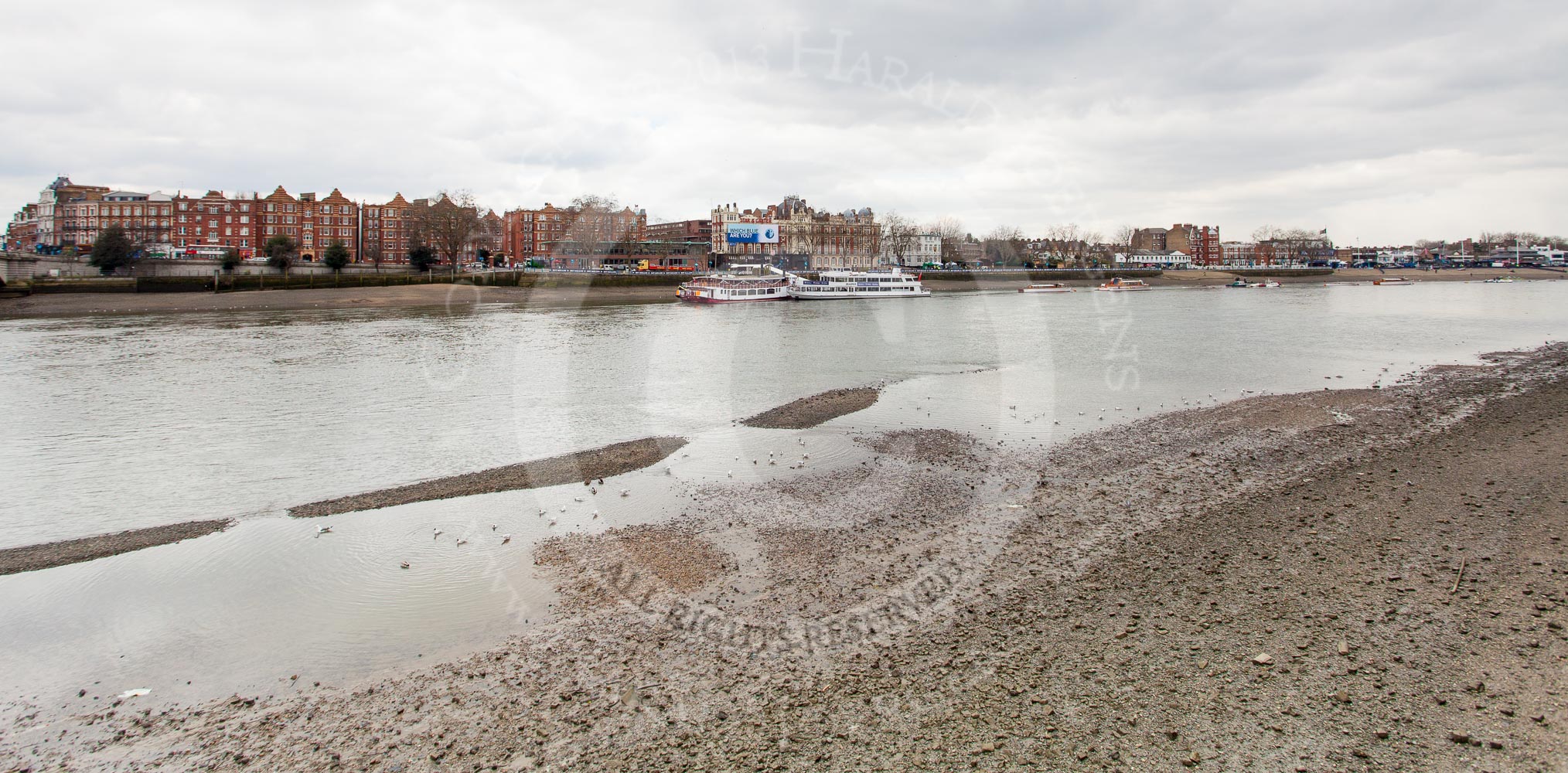 The Boat Race 2013: Putney Embankment seen from the northern side of the River Thames. "Which Blue are you"-billboard by Boat Race sponsor BNY Mellon ouside the Star & Garter River Bar & Eaterty in the centre of the iage, behind the passenger boats at Putney Pier..
Putney,
London SW15,

United Kingdom,
on 31 March 2013 at 11:38, image #29