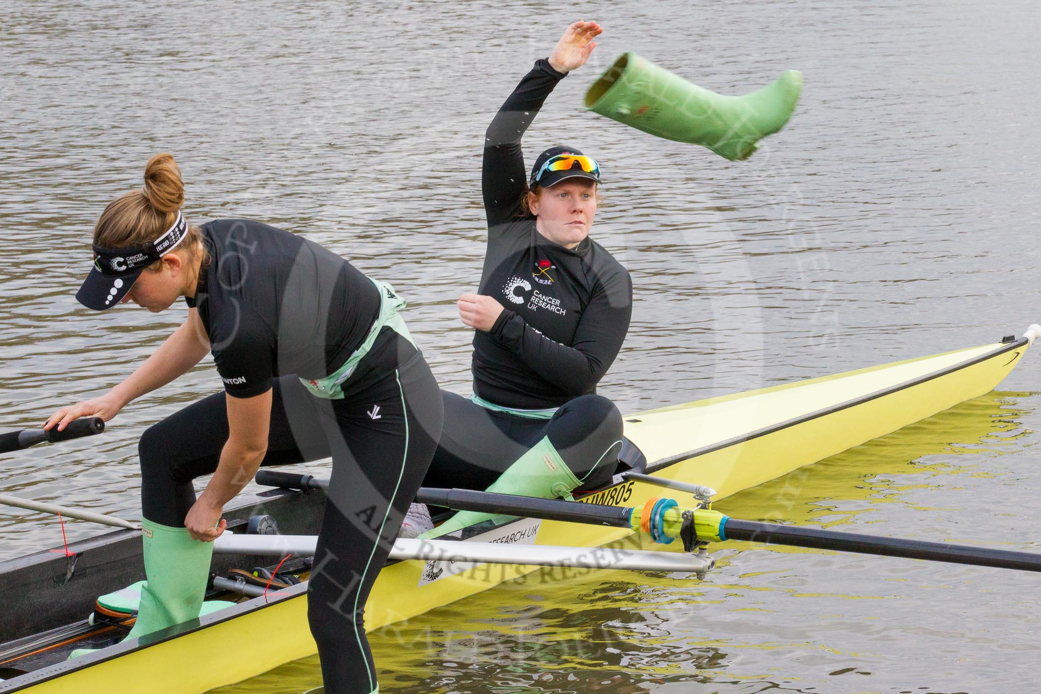 The Boat Race season 2017 - Women's Boat Race Fixture CUWBC vs Univerity of London: CUWBC's 2, Kirsten van Fosen, and bow Claire Lamb getting rid of their Wellies.
River Thames between Putney Bridge and Mortlake,
London SW15,

United Kingdom,
on 19 February 2017 at 15:16, image #9