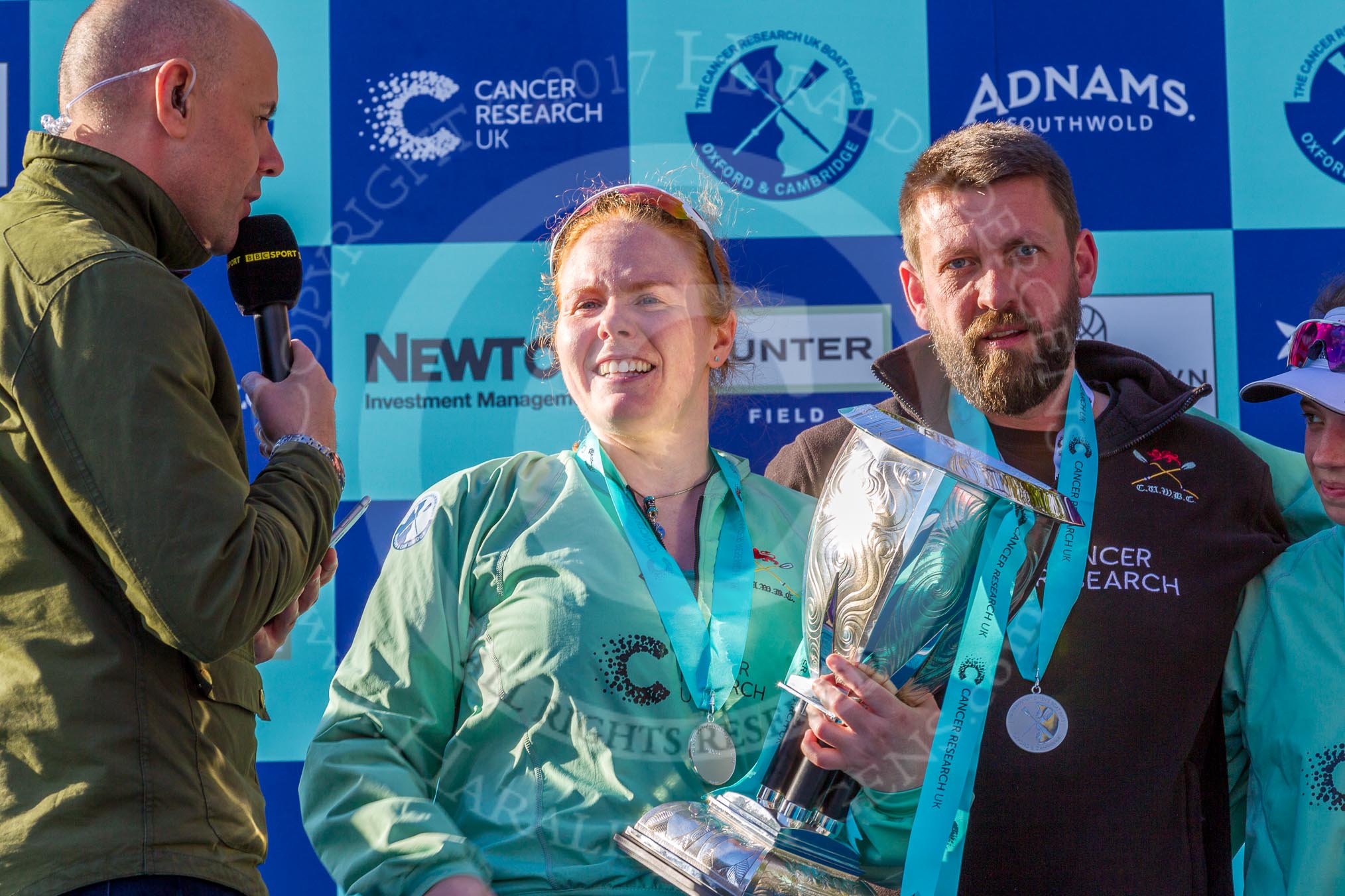 The Boat Race season 2017 -  The Cancer Research Women's Boat Race: CUWBC president Ashton Brown, with the Women's Boat Race trophy, being interviewed by the BBC's Jason Mohammad. On the right CUWBC head coach Rob Barker.
River Thames between Putney Bridge and Mortlake,
London SW15,

United Kingdom,
on 02 April 2017 at 17:11, image #242
