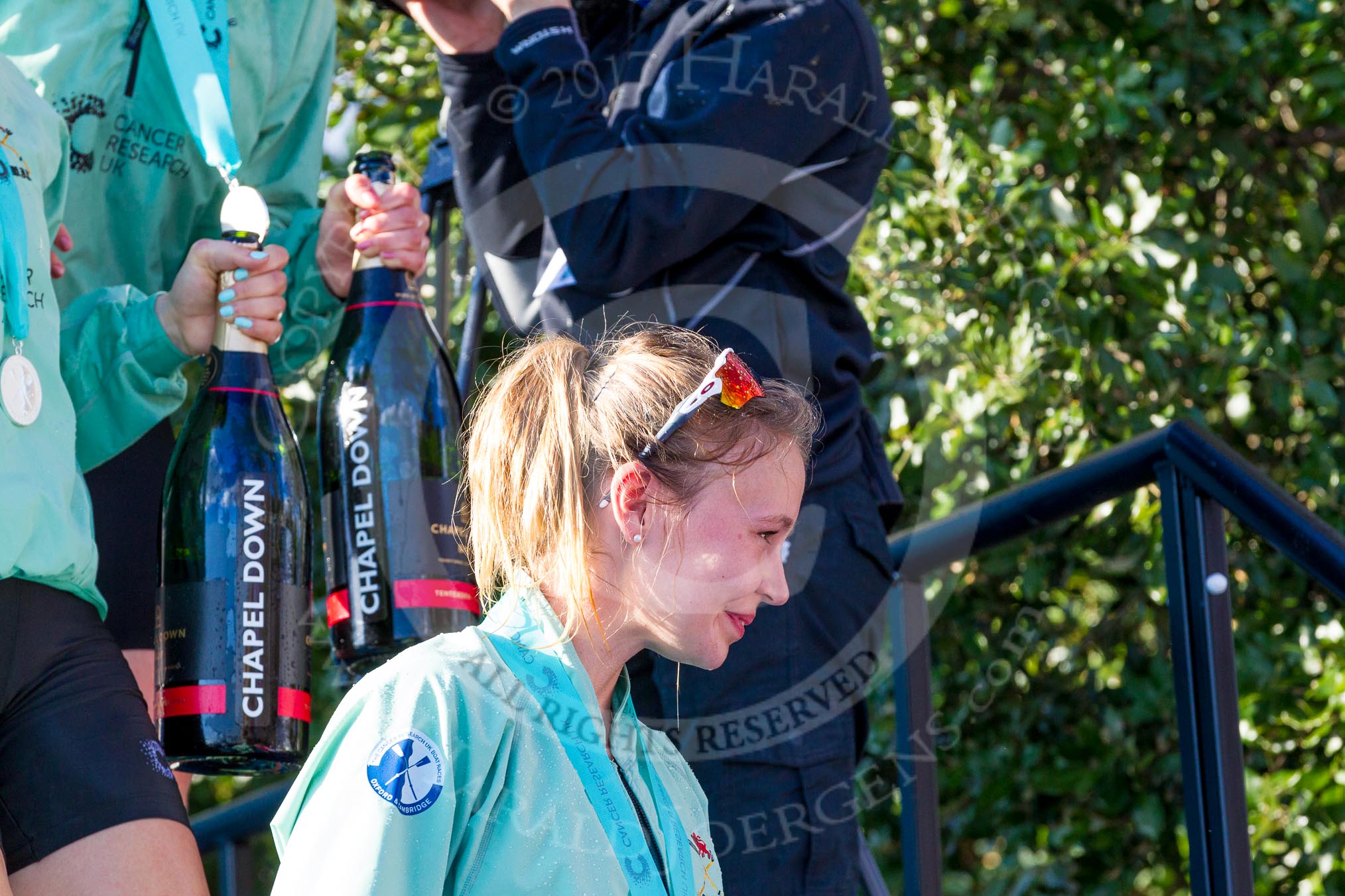 The Boat Race season 2017 -  The Cancer Research Women's Boat Race: CUWBC's 3 seat Claire Lambe leaving the price giving, with two bottles of Chapel Down Champagne, carried by other crew members.
River Thames between Putney Bridge and Mortlake,
London SW15,

United Kingdom,
on 02 April 2017 at 17:14, image #304