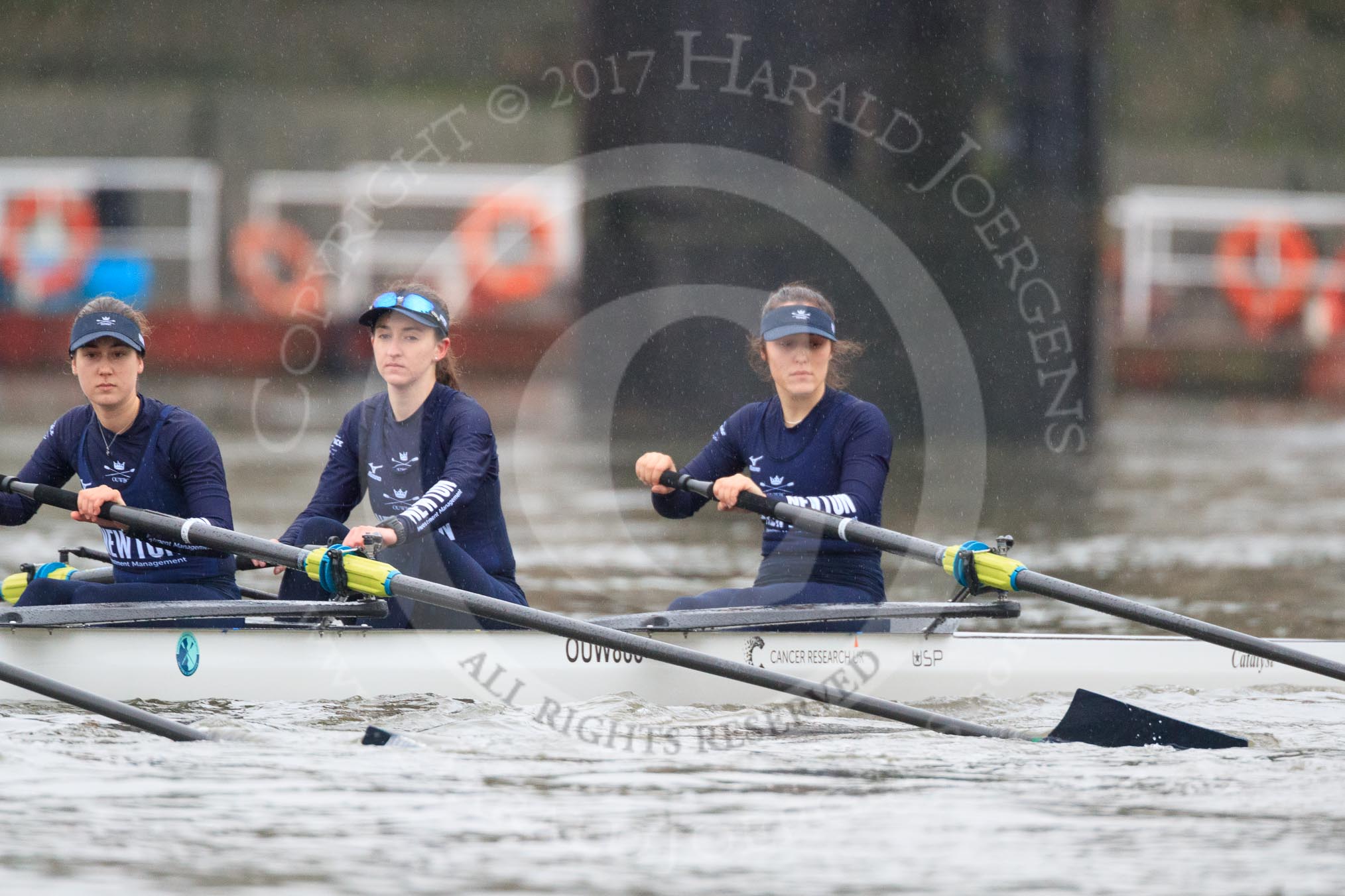 The Boat Race season 2018 - Women's Boat Race Trial Eights (OUWBC, Oxford): Rowing towards the start line in the rain - "Great Typhoon" with 3 Madeline Goss, 2 Laura Depner, bow Matilda Edwards.
River Thames between Putney Bridge and Mortlake,
London SW15,

United Kingdom,
on 21 January 2018 at 14:24, image #41