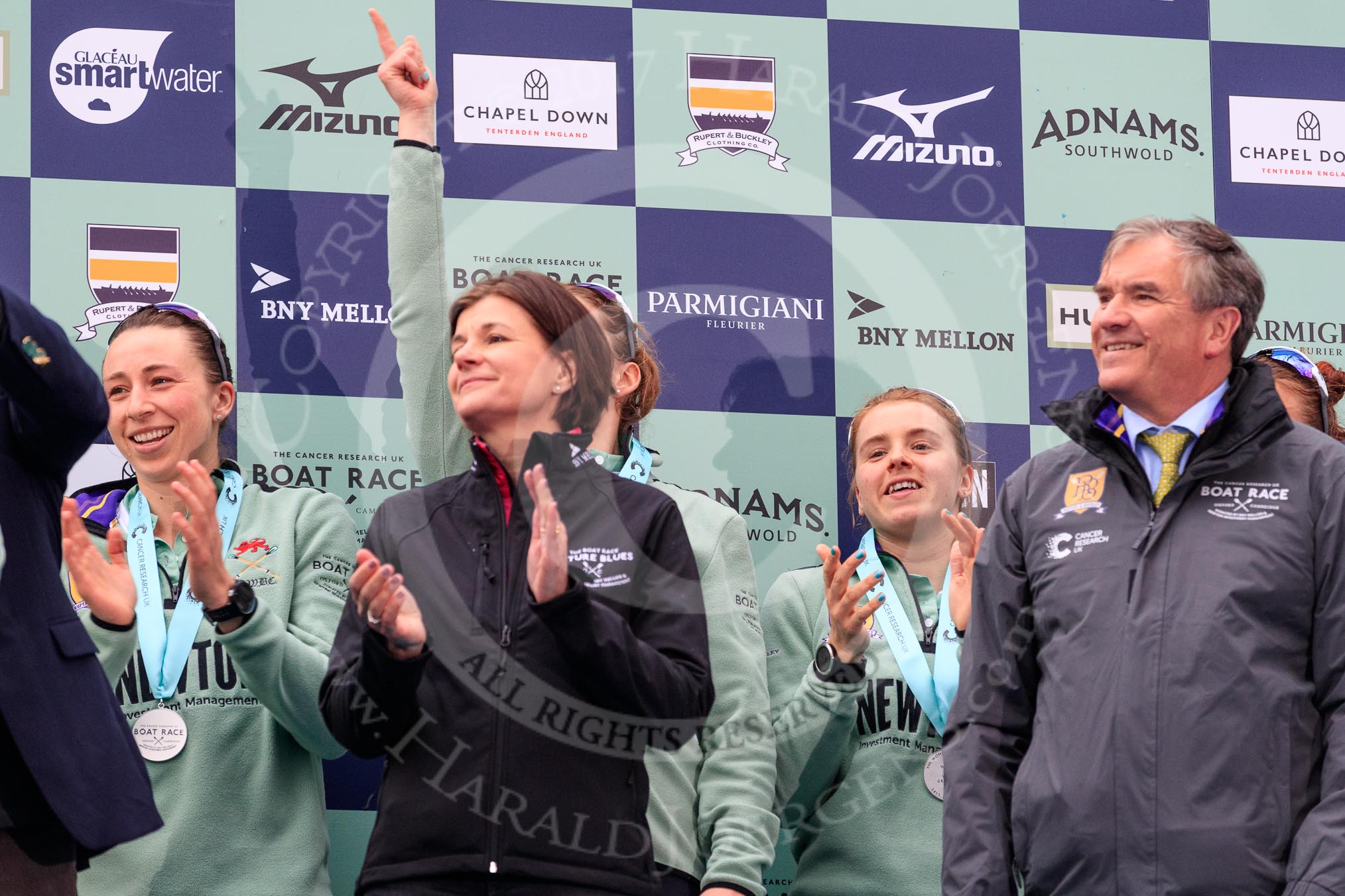 The Cancer Research UK Women's Boat Race 2018: The Women's Boat race presentation - Cambridge stroke Ollivia Coffey, Newton Investment CEO Hanneke Smits, hidden behind her 7 seat Myriam Goudet-Boukhatmi, 6 then Alice White, and Boat Race Company director Fergus Murison.
River Thames between Putney Bridge and Mortlake,
London SW15,

United Kingdom,
on 24 March 2018 at 17:07, image #264