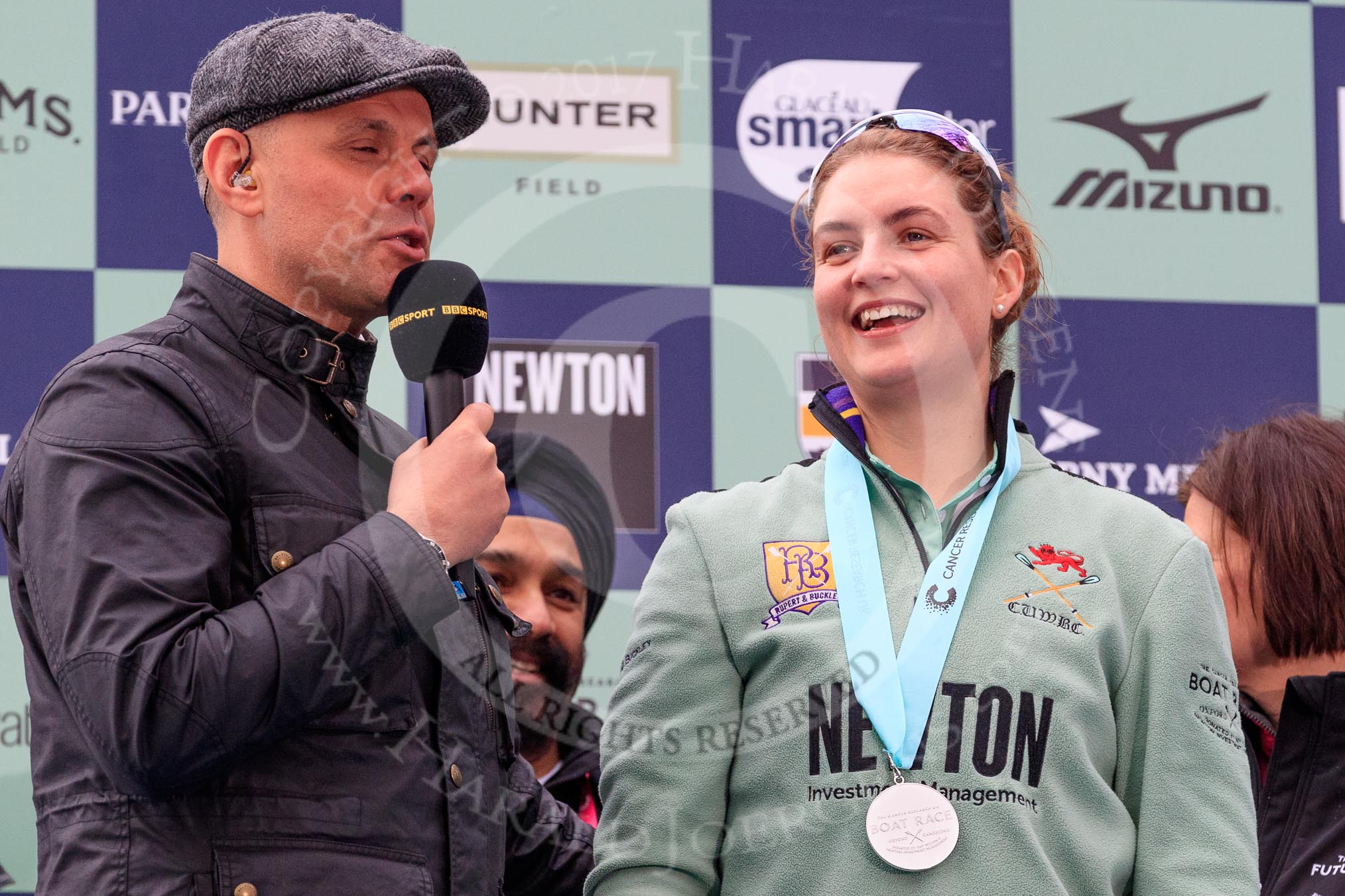 The Cancer Research UK Women's Boat Race 2018: BBC's Sport commentator Jason Mohammad with Cambridge 7 seat Myriam Goudet-Boukhatmi, behind them Cancer Research UK CEO Sir Harpal Kumar.
River Thames between Putney Bridge and Mortlake,
London SW15,

United Kingdom,
on 24 March 2018 at 17:07, image #266