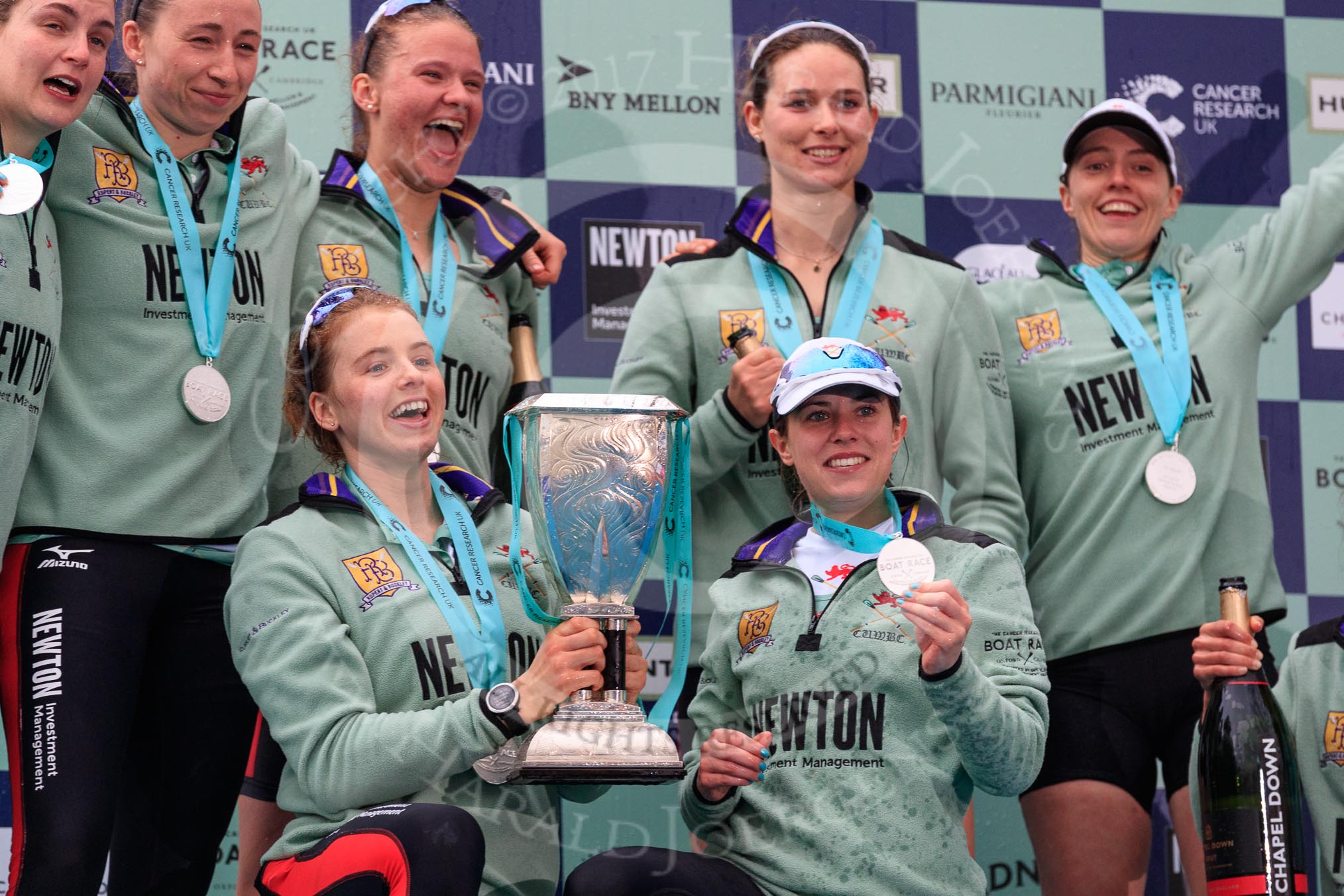 The Cancer Research UK Women's Boat Race 2018: The Cambridge women celebrating with their Boat Race medals, the Women's Boat Race trophy, and lots of Chapel Down Brut: Myriam Goudet-Boukhatmi , Olivia Coffey, Paula Wesselmann, The Zabell, Alice White, and Sophie Shapter.
River Thames between Putney Bridge and Mortlake,
London SW15,

United Kingdom,
on 24 March 2018 at 17:09, image #297