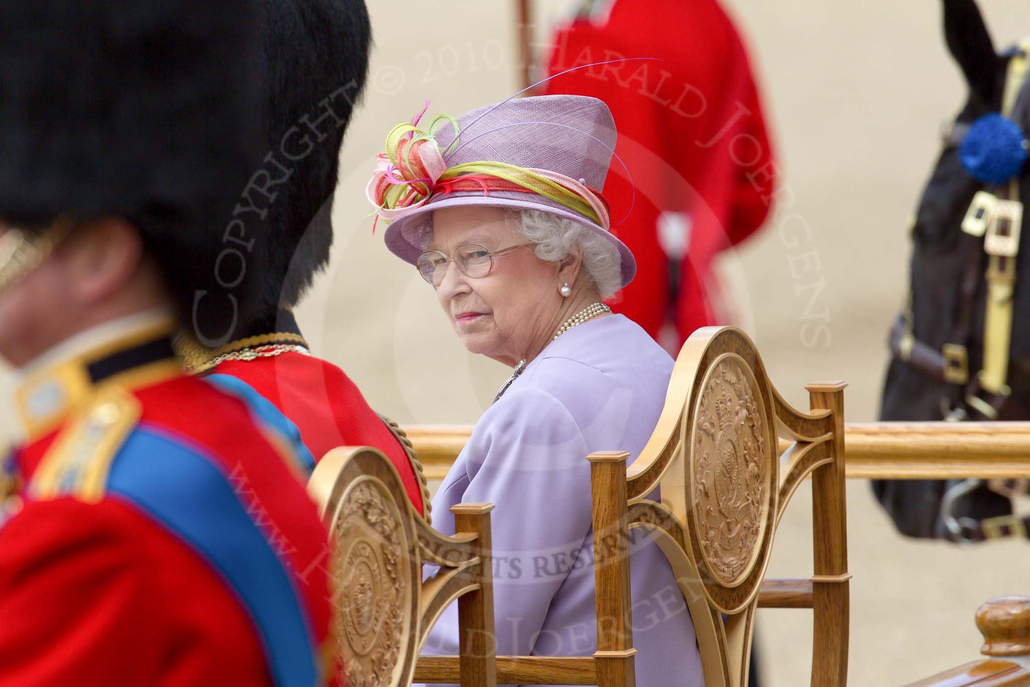 Trooping the Colour 2010: Her Majesty the Queen, Elizabeth II, and The Prince Philip. Duke of Edinburgh, during the &quot;Massed Bands Troop&quot;, sitting in their chairs on the saluting dais.

In the foreground, out of focus, and almost &quot;hiding&quot; The Duke of Edinburgh, can be seen Prince Edward, the Duke of Kent..
Horse Guards Parade, Westminster,
London SW1,
Greater London,
United Kingdom,
on 12 June 2010 at 11:35, image #139