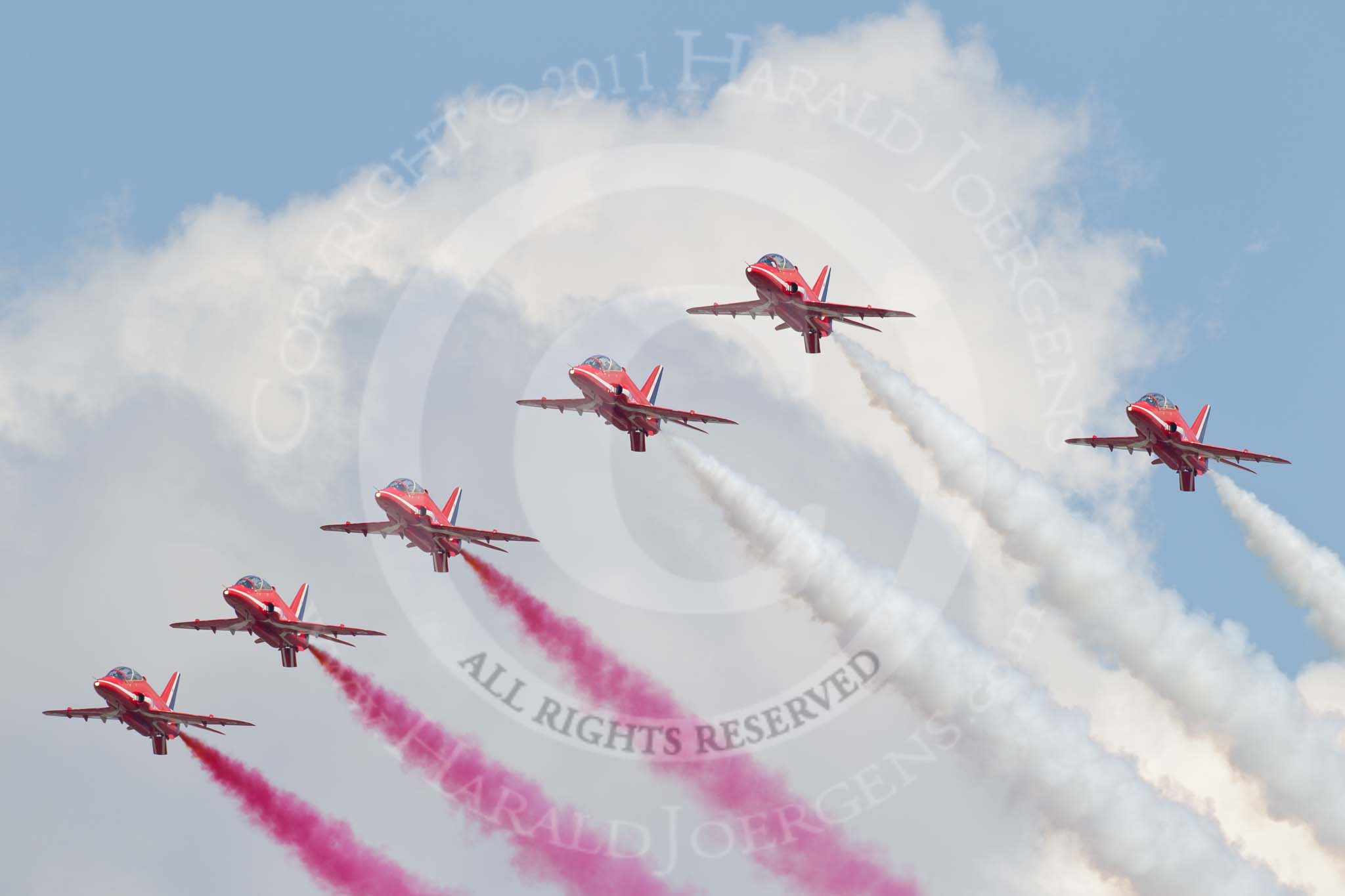 Trooping the Colour 2011: The Red Arrows, displaying red, white, and blue smoke from their Hawk aircraft, during the fly-past over Buckingham Palace..
Horse Guards Parade, Westminster,
London SW1,
Greater London,
United Kingdom,
on 11 June 2011 at 13:03, image #448