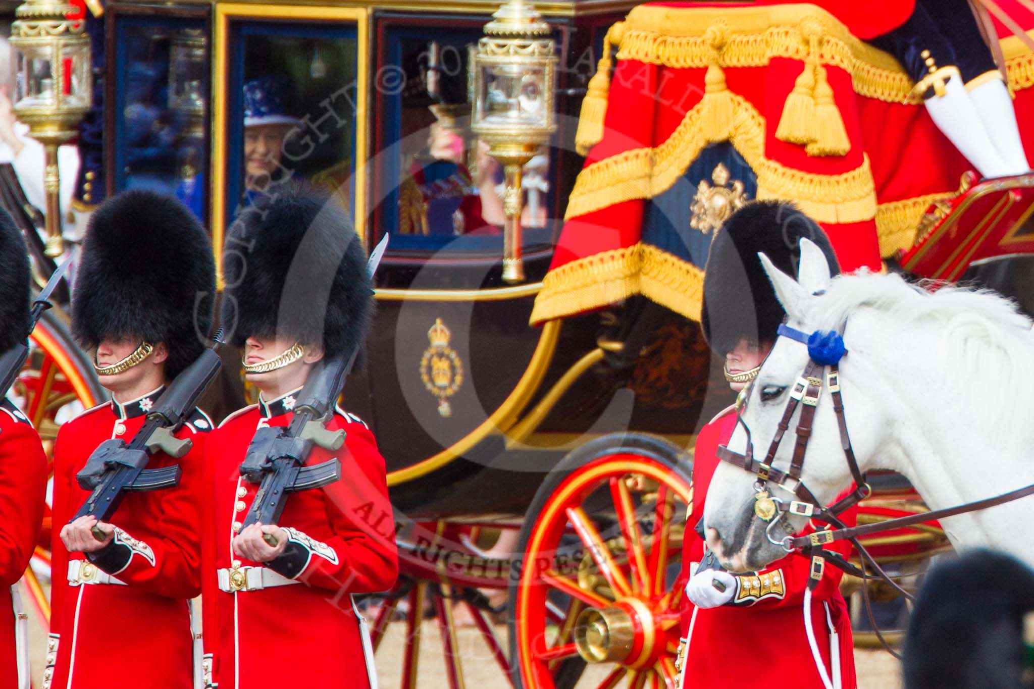 Trooping the Colour 2013: A change of focus - men from No. 6 Guard, No. 7 Company Coldstream Guards, and behind them the Glass Coach carrying HM The Queen. Image #261, 15 June 2013 10:58 Horse Guards Parade, London, UK