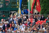 Spectators on the A grandstand, with the Band of the Welsh Guards in the background, turning from The Mall to Horse Guards Parade during The Colonel's Review 2018 (final rehearsal for Trooping the Colour, The Queen's Birthday Parade)  at Horse Guards Parade, Westminster, London, 2 June 2018, 10:10.