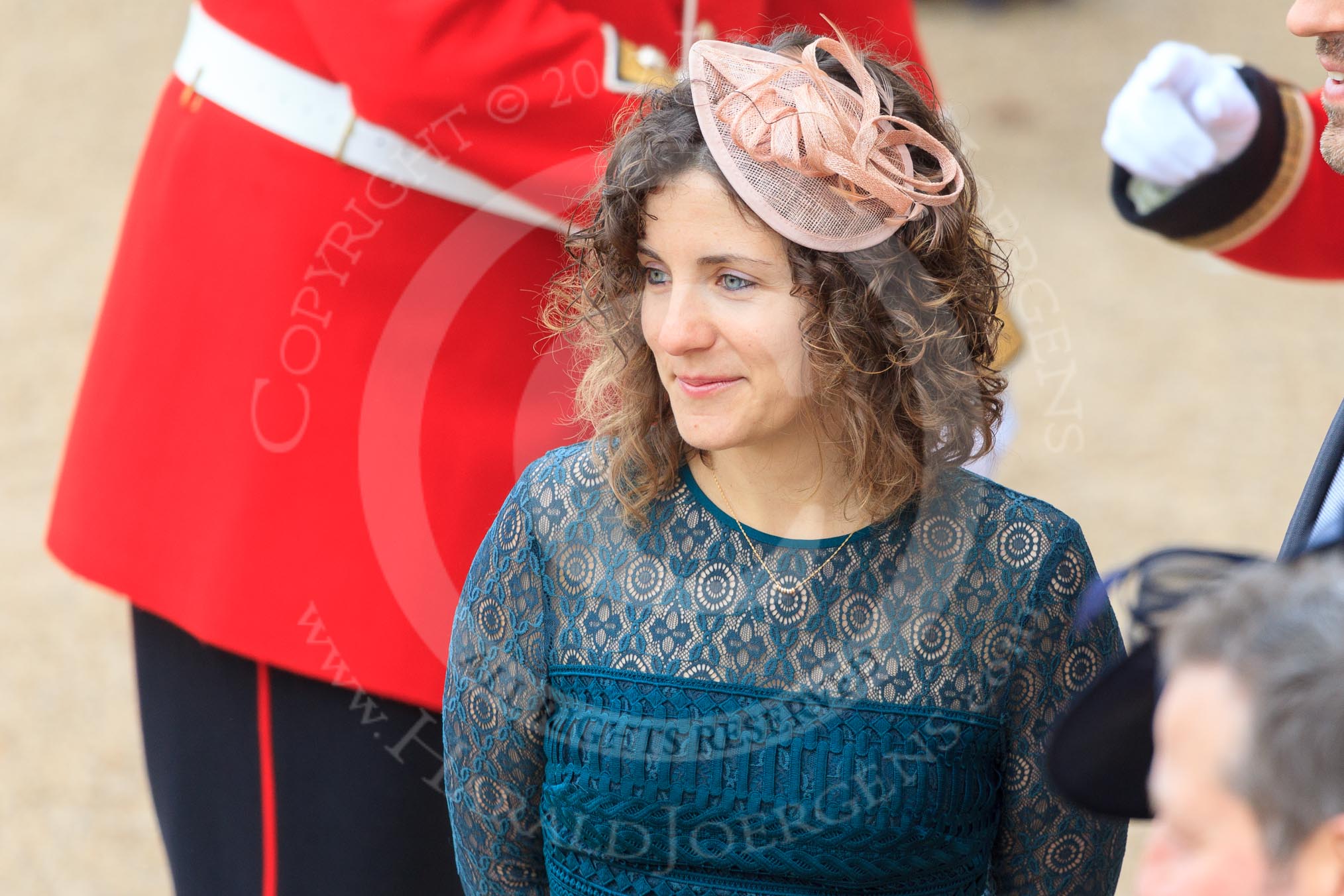 Curly haired woman wearing a fascinator before Trooping the Colour 2018, The Queen's Birthday Parade at Horse Guards Parade, Westminster, London, 9 June 2018, 09:15.