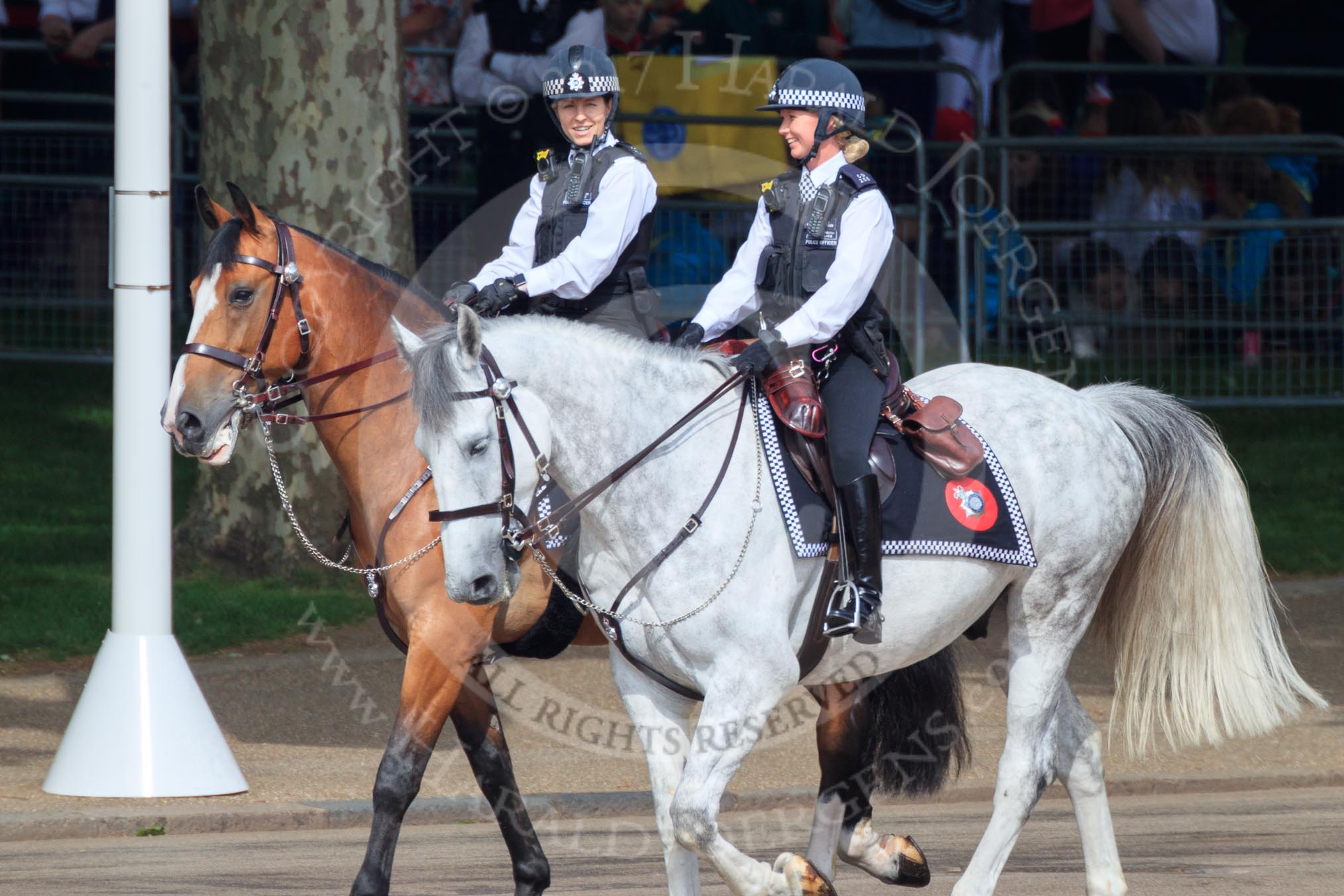 Two female Metropolitan Police officers on horseback, riding past the Youth Enclosure, before Trooping the Colour 2018, The Queen's Birthday Parade at Horse Guards Parade, Westminster, London, 9 June 2018, 09:47.