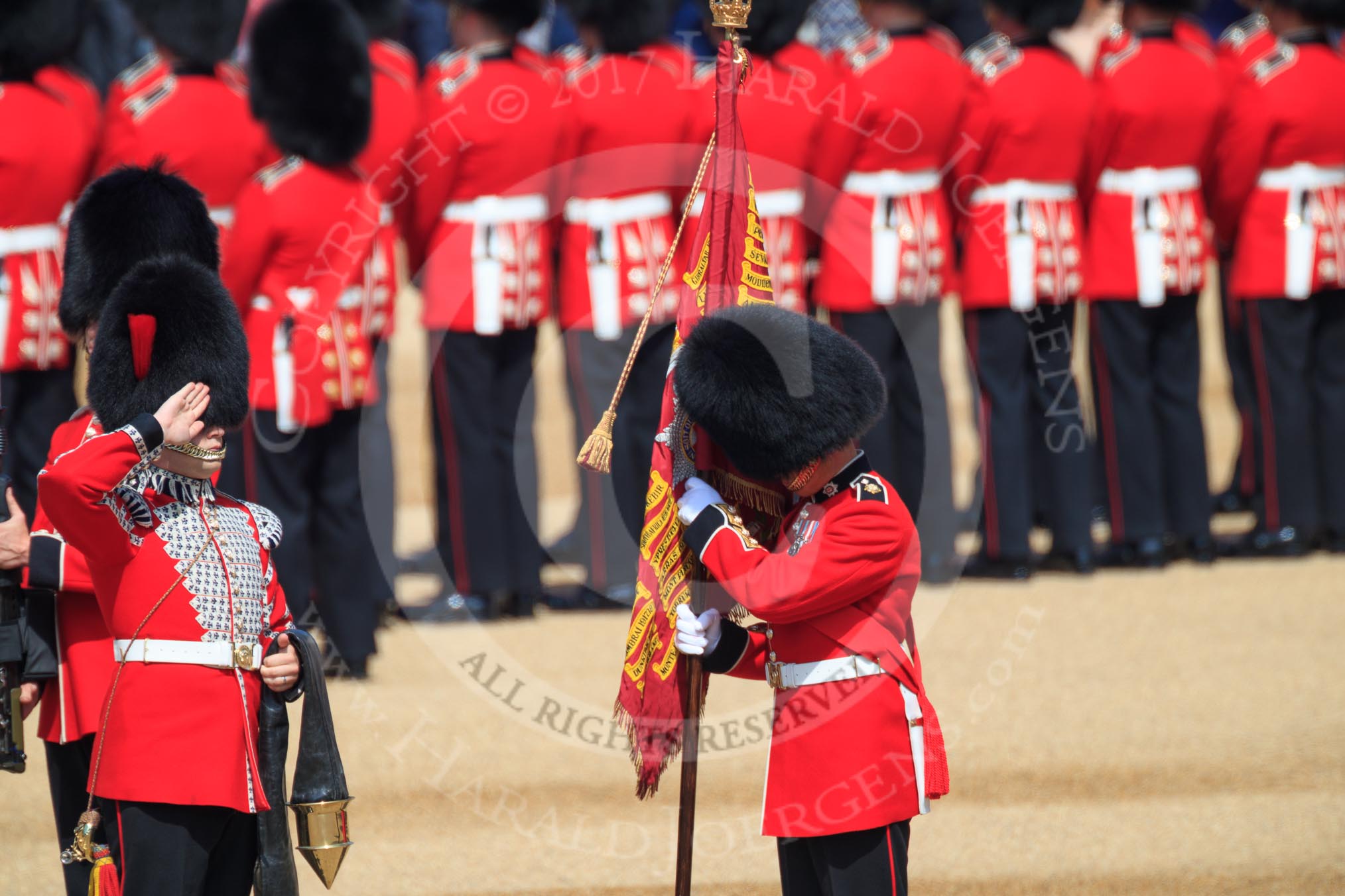 The Duty Drummer Sam Orchard salutes the Colour after removing the case from the Colour held by the Colour Sergeant Sam McAuley (31)  during Trooping the Colour 2018, The Queen's Birthday Parade at Horse Guards Parade, Westminster, London, 9 June 2018, 10:33.