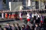 Following the Forces Chaplain and the Bishop of London, Cross Bearer, the 10 Children of the Chapel Royal, and the 6 Gentlemen-in-Ordinary ares leaving Whitehall towards the Foreign- and Commonwealth Office building.